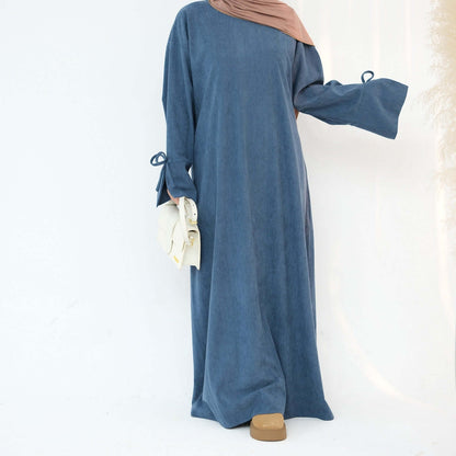 Nawal Corduroy Abaya in soft blue, featuring adjustable tie sleeves and a modern design for everyday elegance.